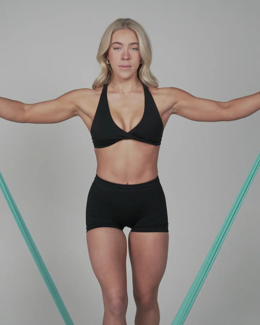 Athlete holding a teal GoLevita flat band spread wide