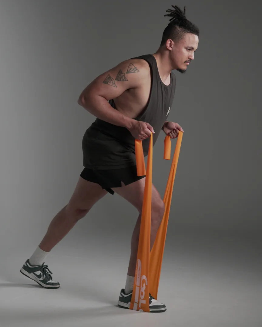 Athlete in a staggered stance loading an orange power band